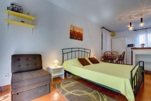 a bedroom with a bed and a chair at Apartments Aurora in Pomer