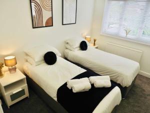Dos camas individuales en una habitación con ventana. en Convenient 2 Bedroom Home with Parking in Taunton, en Taunton