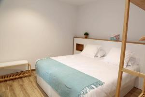 a bedroom with a bed with white sheets and a ladder at La Estrella de Tarsis in Santillana del Mar