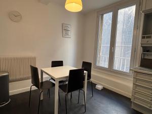 a dining room with a white table and chairs at App centre-ville près du château, grand appartement in Caen