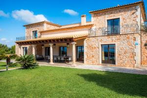 une maison en pierre avec un balcon et une cour dans l'établissement Casa Fortuna, à Manacor