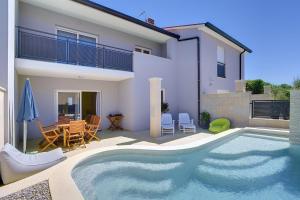 ein Swimmingpool vor einem Haus in der Unterkunft Holiday Home Baldini in Banjole