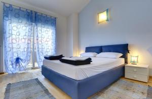 ein blaues Bett in einem Zimmer mit Fenster in der Unterkunft Holiday Home Baldini in Banjole