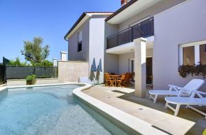 eine Villa mit Swimmingpool und ein Haus in der Unterkunft Holiday Home Baldini in Banjole