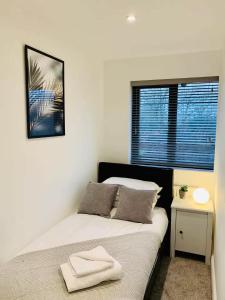 a bedroom with a bed and a window at Spacious 3 Bedroom House with Parking in Taunton in Taunton