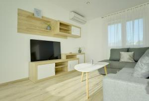 a living room with a couch and a tv and a table at House Bellissima in Vodnjan