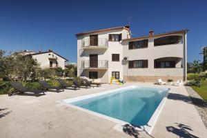 a house with a swimming pool in front of a building at Apartment Falu in Štinjan