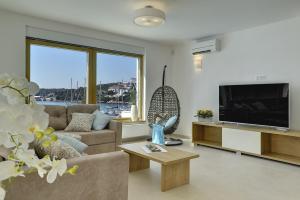 a living room with a couch and a tv at Villa Sail in Pješčana Uvala 