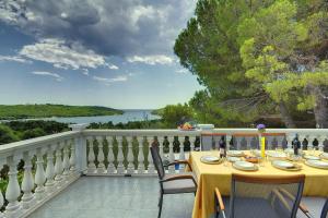 a table on a balcony with a view of the water at Villa Mima in Banjole