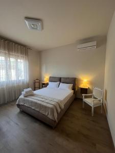 a bedroom with a large bed and a chair at Villetta dei nonni in Monsummano Terme