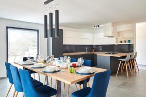 a kitchen with a wooden table and blue chairs at Villa Dolcea in Umag