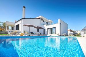 a villa with a swimming pool in front of a house at Villa Dolcea in Umag