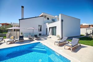 a villa with a swimming pool and a house at Villa Dolcea in Umag