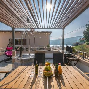 einen Holztisch mit Obst auf der Terrasse in der Unterkunft Villa Porto in Krnica