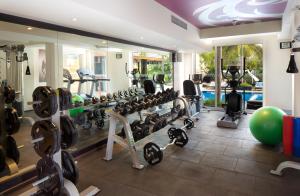 une salle de remise en forme avec des tapis de course et une piscine dans l'établissement Hard Rock Hotel Goa Calangute, à Calangute