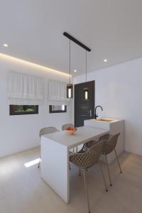 a kitchen with a white table and chairs at 3-bedroom villa Penelope in Andiparos