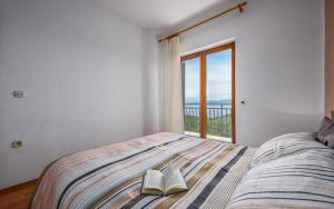 a bedroom with a bed with two books on it at Ferienwohnung 5235-3 in Drenje in Drenje
