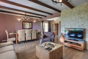 a living room with a television and a dining room at Villa Ari in Krnica