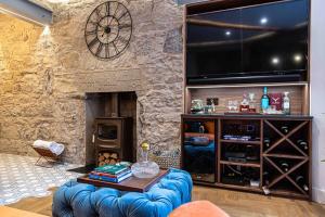 a living room with a stone wall with a large television at Canon Cave in Edinburgh