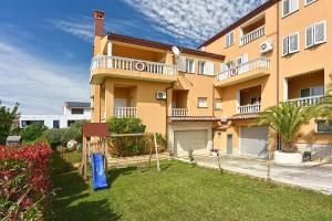 a large apartment building with a yard in front of it at Apartments Sunset in Vodnjan