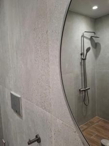 a bathroom with a shower with a round mirror at Grammeno Seaside Studios in Palaiochora +61 photos