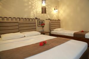 two beds in a room with two roses on the bed at Dardanos Hotel in Patara