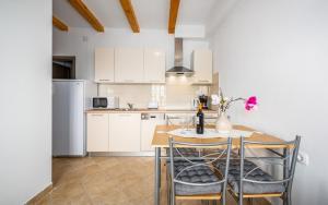 a kitchen with a table and chairs and a refrigerator at Ferienwohnung 5235-8 in Drenje in Drenje