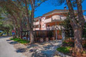 ein Gebäude mit Bäumen vor einer Straße in der Unterkunft Apartment Sana in Medulin
