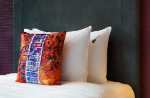 a bed with three pillows on it next to a wall at Hard Rock Hotel Goa Calangute in Calangute +49 photos