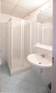 un bagno bianco con lavandino e doccia di Hotel Europa ad Arma di Taggia