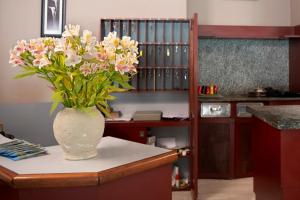 un vaso pieno di fiori appoggiato su un tavolo di Hotel Europa ad Arma di Taggia