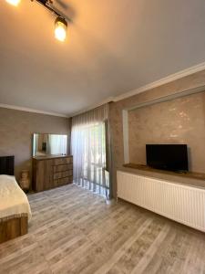 una camera da letto con un letto e una TV a schermo piatto di Cottage a Borjomi