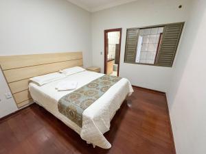 a bedroom with a bed and a window at Casa Completa à 100m do Parque de Exposição in Patos de Minas