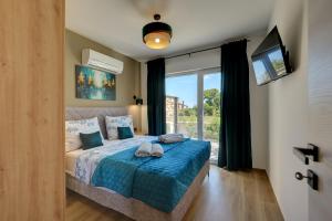 una camera da letto con un letto con lenzuola blu e una finestra di Villa Pieron a Barban Altre 27 foto