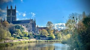 a large cathedral with a river in front of it at The Crown in Martley