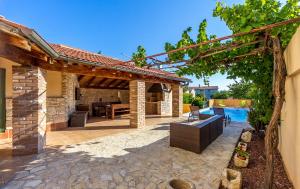 an outdoor patio with a pergola and a swimming pool at Villa Teresa in Medulin