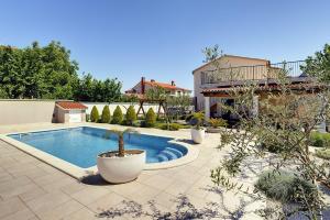 a backyard with a swimming pool and a house at Villa Iva in Medulin