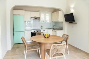 a kitchen with a wooden table with chairs and a bowl on it at Taxi Driver Apartments in Paleokastritsa