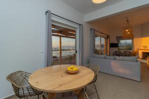 a dining room with a wooden table and chairs at Phaos in Kyparissia