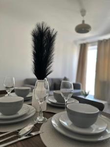 a dining room table with plates and glasses and a plant at Stylish 2 Bedroom Flat Slough in Slough +11 photos