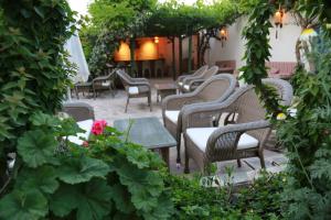 an outdoor patio with chairs and tables and plants at Dardanos Hotel in Patara