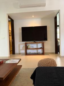 a living room with a flat screen tv on a wall at Selva Tulum - HiveNB in Tulum