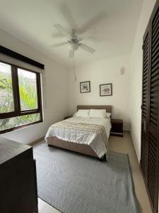 a bedroom with a bed and a ceiling fan at Selva Tulum - HiveNB in Tulum +30 photos