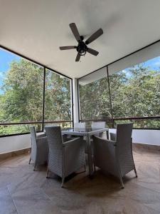 a dining room with a table and chairs and windows at Selva Tulum - HiveNB in Tulum