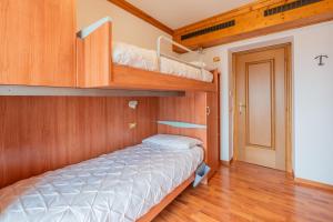 1 dormitorio con 2 literas y pasillo en CASA VIDI, en Madonna di Campiglio