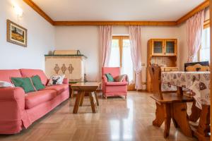 sala de estar con sofá rosado y sillas en CASA VIDI, en Madonna di Campiglio