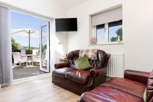 a leather chair in a living room with a sliding glass door at Finest Retreats - Torino Lodge in Newbridge