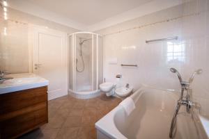 a bathroom with a tub and a toilet and a sink at Apartment Villa Laurin in Pianizza di Sotto +15 photos