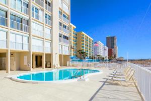 a swimming pool with lounge chairs and a building at The Edgewater 44 in Gulf Shores