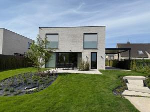 a modern house with a grass yard at Maison Impression vakantiehuis in Middelkerke